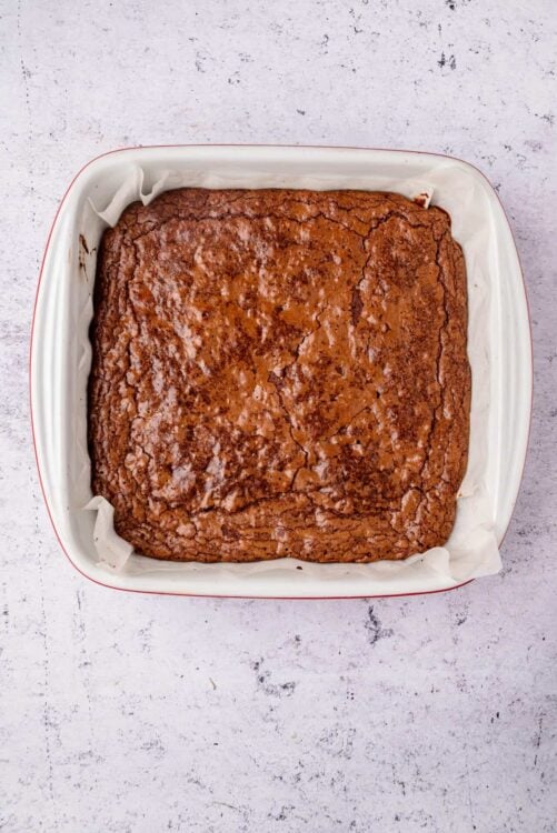 Moist homemade brownies in a baking dish with parchment paper.