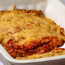 Cheesy baked pasta casserole in a white baking dish with melted cheese topping.