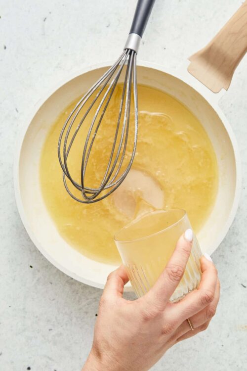 Filling glass with lemon curd in a mixing bowl for baking recipes.