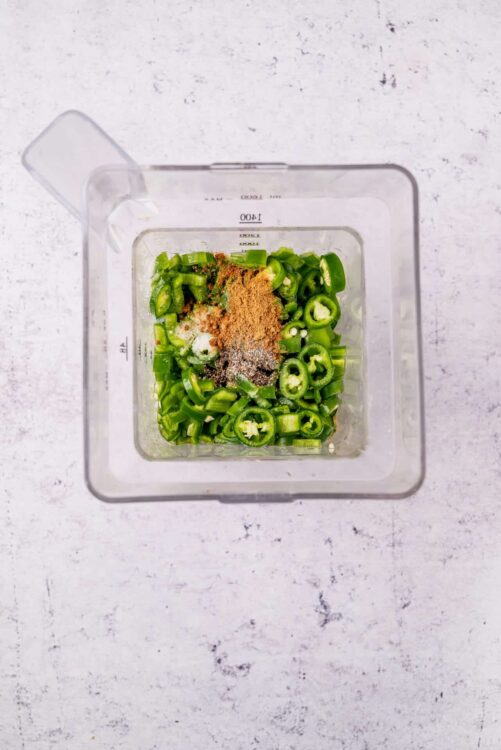 Chopped green onions and spices in a measuring cup for baked recipe.