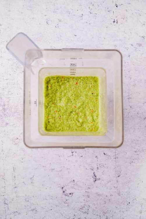 Bright green herb-infused oil in a measuring cup, ready for cooking or marinade.
