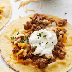 Savory beef taco with cheese and sour cream on a soft flour tortilla.