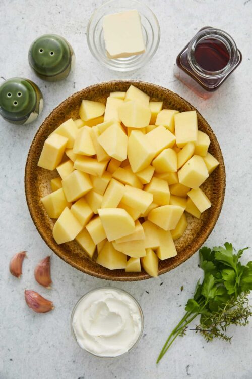 Diced potatoes with garlic, cream, butter, and herbs for creamy potato dish.