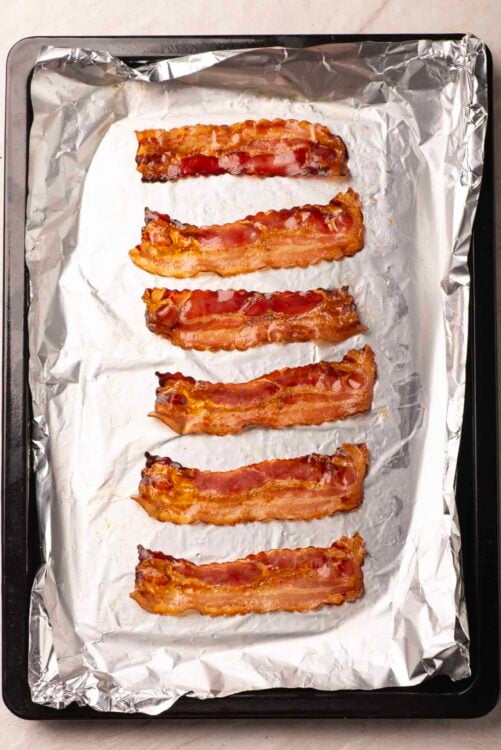 Crispy baked bacon on foil-lined baking sheet.