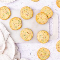 Colorful sprinkle sugar cookies on a white surface, perfect for parties and celebrations.
