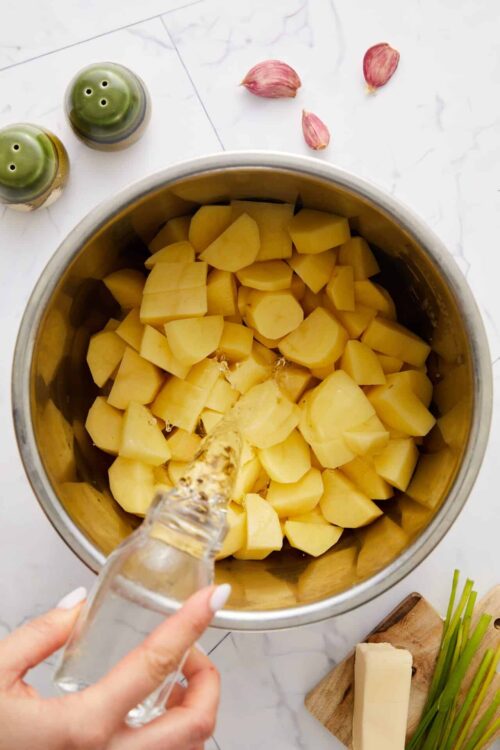 Potato preparation in a food processor for baked potato recipe.