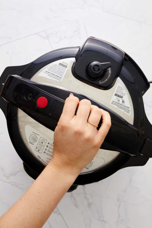 Baked bree air fryer handle close-up, modern kitchen appliance cooking, compact air fryer on marble countertop.