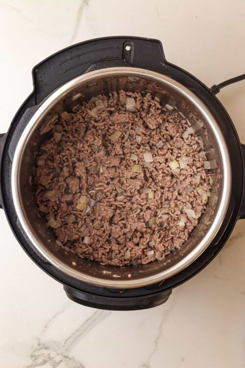 Ground beef cooking with onions in an Instant Pot.