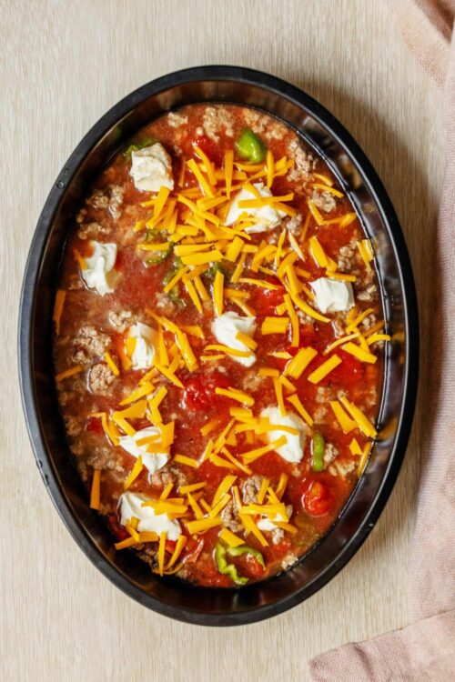 Shredded cheese, sour cream, and cooked ground beef in a chili or taco casserole.