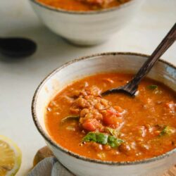 Savory lentil soup in rustic ceramic bowls.
