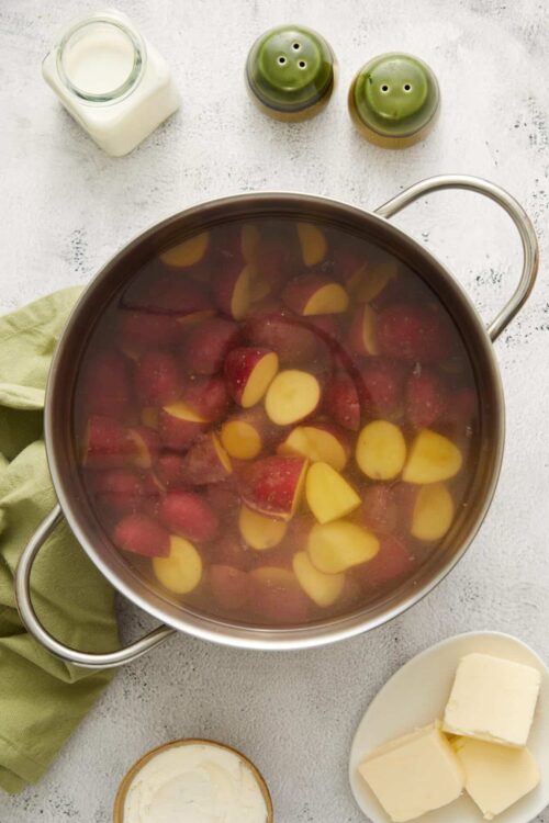 Fresh red potatoes and garlic boiling in a large pot for delicious baked potato dishes.