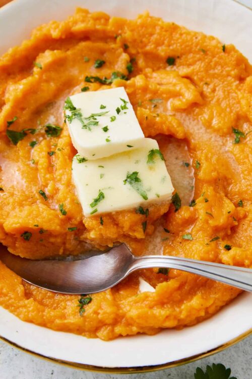 Creamy mashed sweet potatoes with butter and herbs.