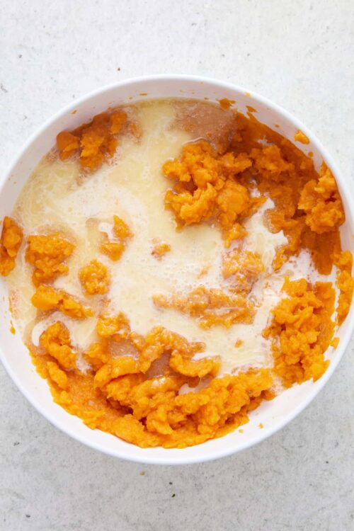 Golden sweet potato mash with butter in a white bowl, easy healthy side dish recipe.