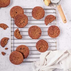 Chewy chocolate chip cookies cooling on a wire rack on a white countertop.