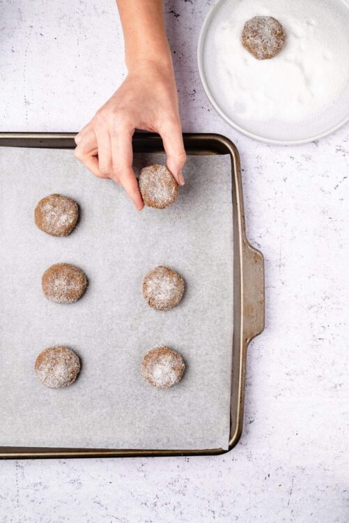 Fried cookies with powdered sugar on a baking sheet.