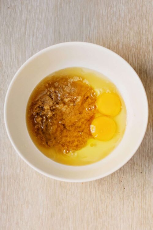 Flour, eggs, and sugar in a mixing bowl for baking recipe.