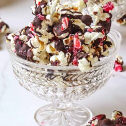 Chocolate peppermint popcorn in elegant glass bowls for festive holiday treat.
