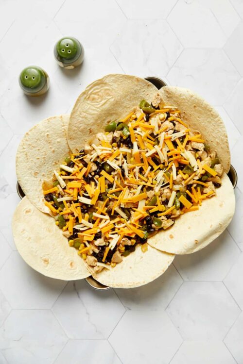 Loaded chicken and cheese taco dip served in tortilla chips, perfect for parties and game day snacks.