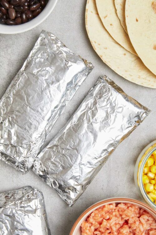 Foil-wrapped taco fillings with fresh tortillas, black beans, corn, and diced tomatoes. Perfect for homemade tacos or burritos.