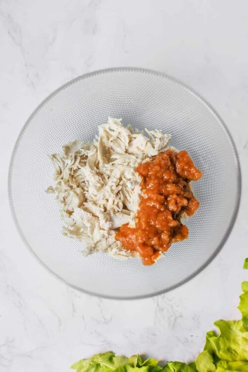 Creamed chicken and tomato sauce in a glass bowl for savory baked dishes.