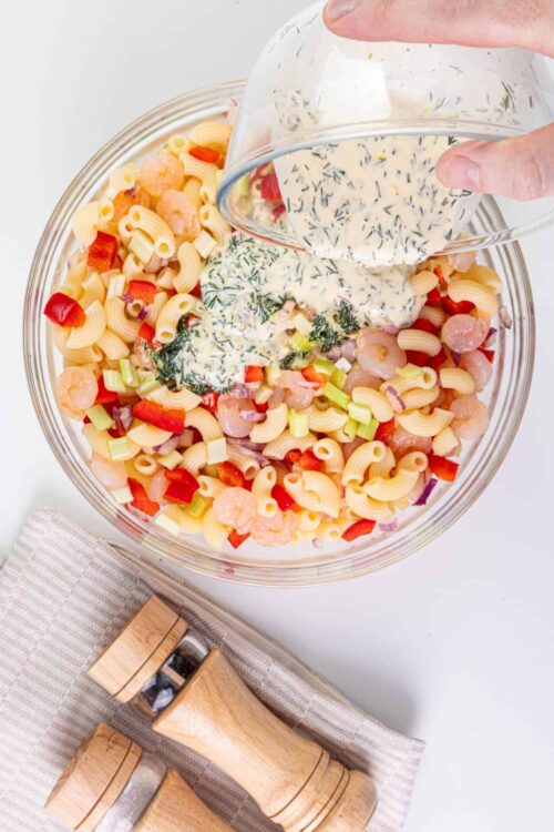 Vibrant pasta salad with shrimp, red bell peppers, celery, and a creamy herb dressing.