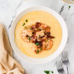Creamy shrimp and bacon chowder served in a white bowl with fresh herbs. Perfect comfort food for a cozy meal.