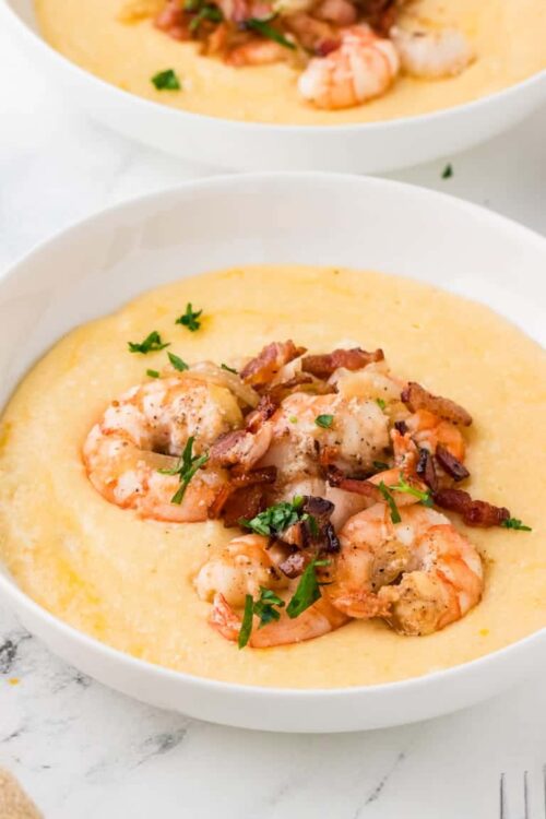 Creamy Shrimp and Bacon Chowder in white bowl, garnished with parsley.