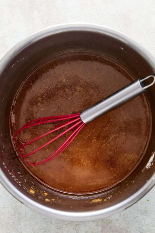 Rich chocolate sauce in mixing pot with whisk. Perfect for baking and dessert recipes.