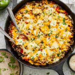 Cheesy beef and vegetable baked casserole in cast iron skillet.