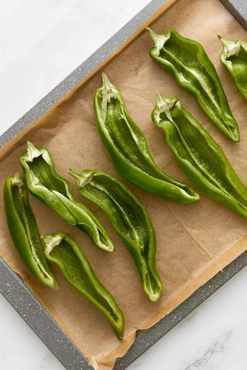 Freshly sliced green bell peppers on baking sheet for healthy cooking or stuffing recipes.