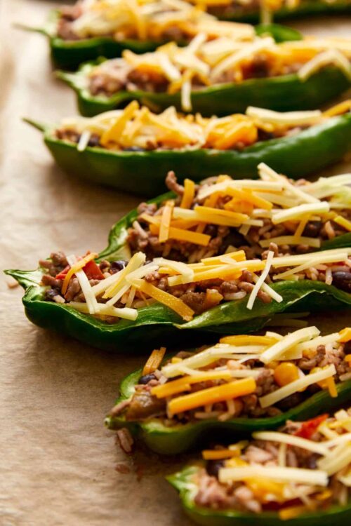 Stuffed jalapeño peppers topped with shredded cheese and cooked ground beef, baked until bubbly and golden. Perfect appetizer or snacks.