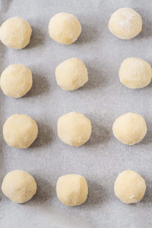 Cream cheese moon cookies ready to bake on parchment paper.