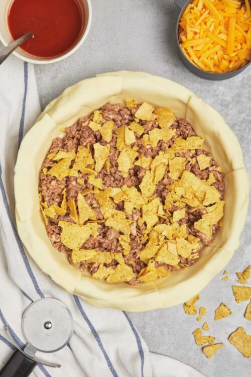 Crispy taco filling with crumbled ground beef and shredded cheese in pie crust.