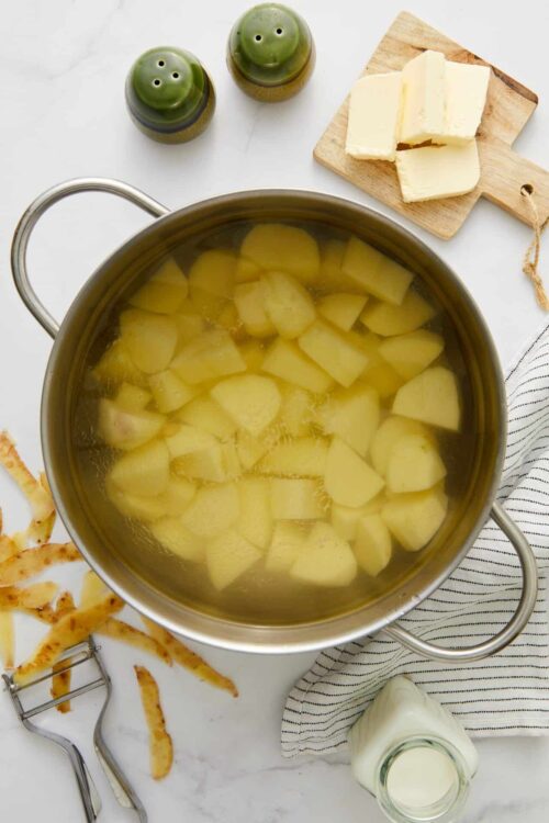 Sliced potatoes boiling in a pot for potato soup or mash.