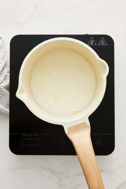 Cream in a mixing bowl on induction cooktop.