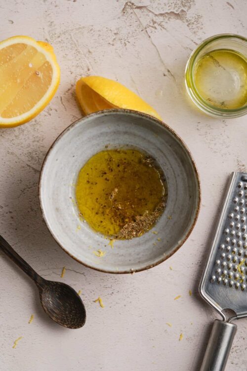 Lemon zest and juice with olive oil and grater on baking surface, ingredients for lemon pastry or dessert.