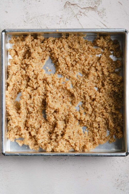 Crispy baked gluten-free quinoa granola clusters on baking sheet.