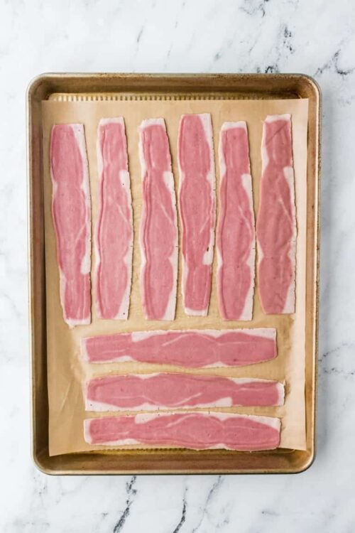 Bacon strips on baking sheet for crispy bacon recipe.