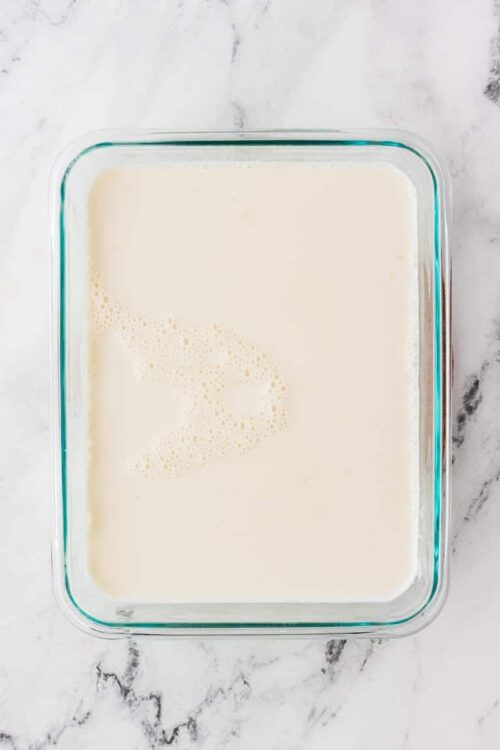 Creamy custard in a glass baking dish ready for baking or chilling. Perfect for making flan, pudding, or dessert casseroles.