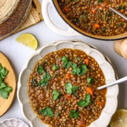 Hearty lentil vegetable soup served in a white bowl with fresh cilantro garnish.