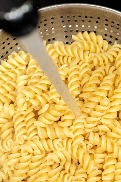 Soft cooked fusilli pasta in a colander, ready for delicious baked pasta recipes.