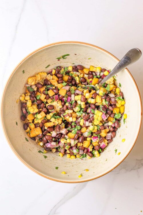 Black bean and corn salad in a bowl with cilantro and red onion.