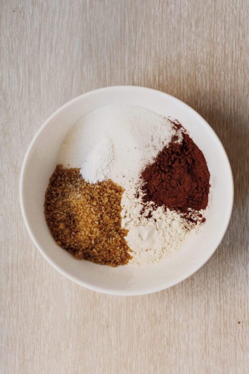 Springerle cookie stamping mold, vanilla, cocoa, and turmeric powders in a bowl.