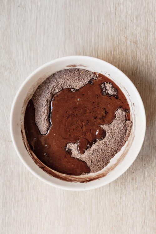 Rich homemade chocolate pudding with smooth, glossy surface and cocoa powder topping.