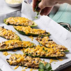 Savory stuffed poblano peppers topped with shredded cheese and fresh herbs. Perfect for a delicious and healthy appetizer or main dish.