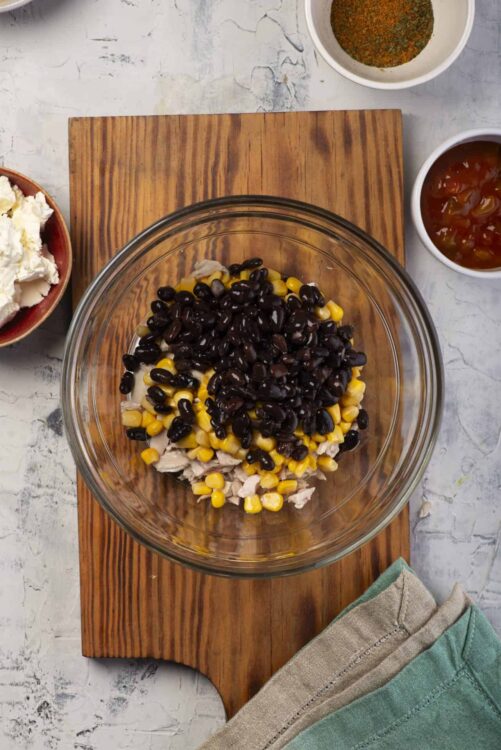 Black bean corn chicken salad ingredients in a glass mixing bowl, fresh and healthy summer dish.