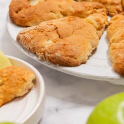 Buttermilk fried chicken tenders on white platter with lime wedges.