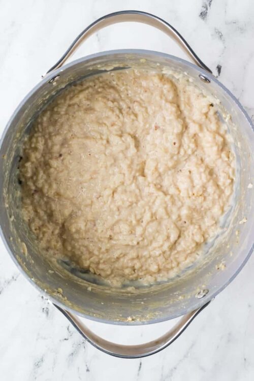 Creamy potato mixture in a stainless steel pot for baking or cooking.