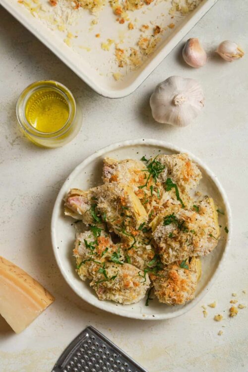 Crispy baked chicken drumsticks garnished with herbs on a white plate. Perfect for flavorful home-cooked meals.