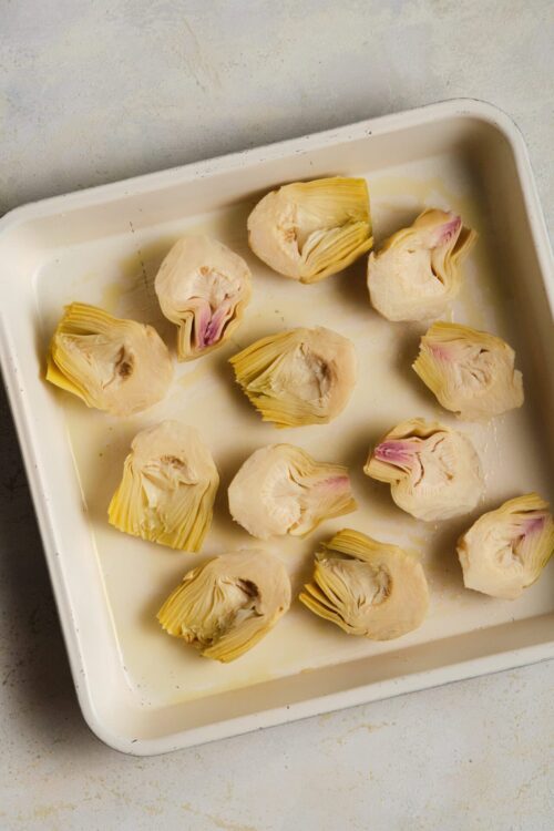 Artichokes on a baking sheet before roasting natural light, cooking, healthy vegetables.